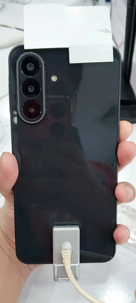 ด้านหลังของ Samsung Galaxy A27 5G สีดำ ถือในมือ แสดงตัวเครื่องพลาสติกมันวาวและโมดูลกล้องสามเลนส์