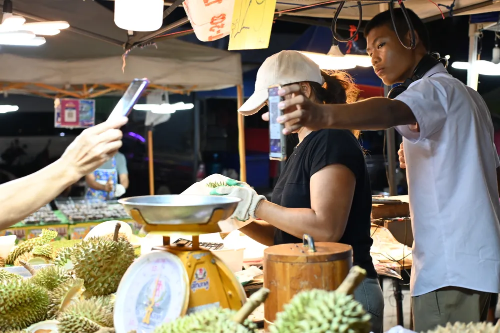 คนไทยใช้โทรศัพท์มือถือจ่ายเงินที่ตลาดสด