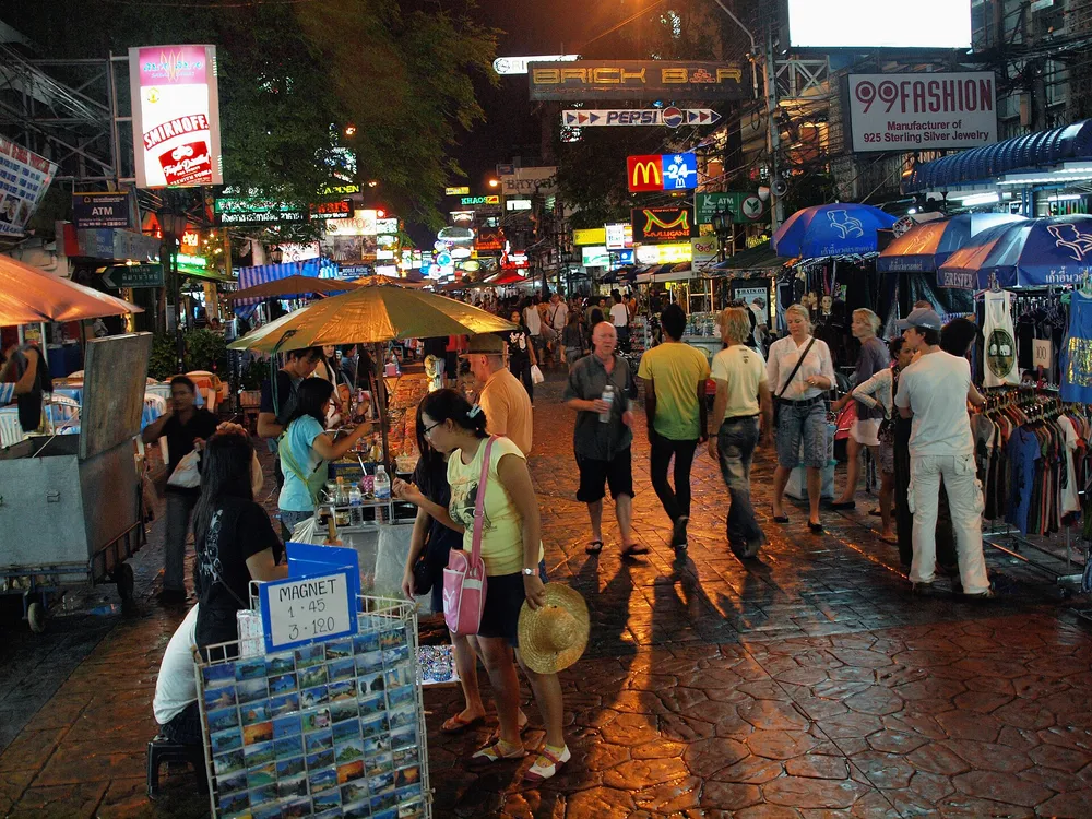 ถนนข้าวสาร กรุงเทพฯ ยามค่ำคืนที่มีนักท่องเที่ยวและแสงไฟสีสันสดใส