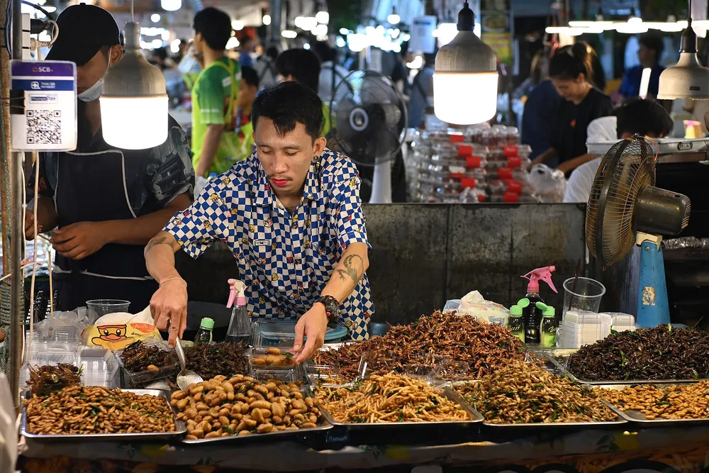 ตลาดที่พ่อค้าแม่ค้ารับชำระเงินด้วย QR แบบดิจิทัลควบคู่ไปกับเงินสด